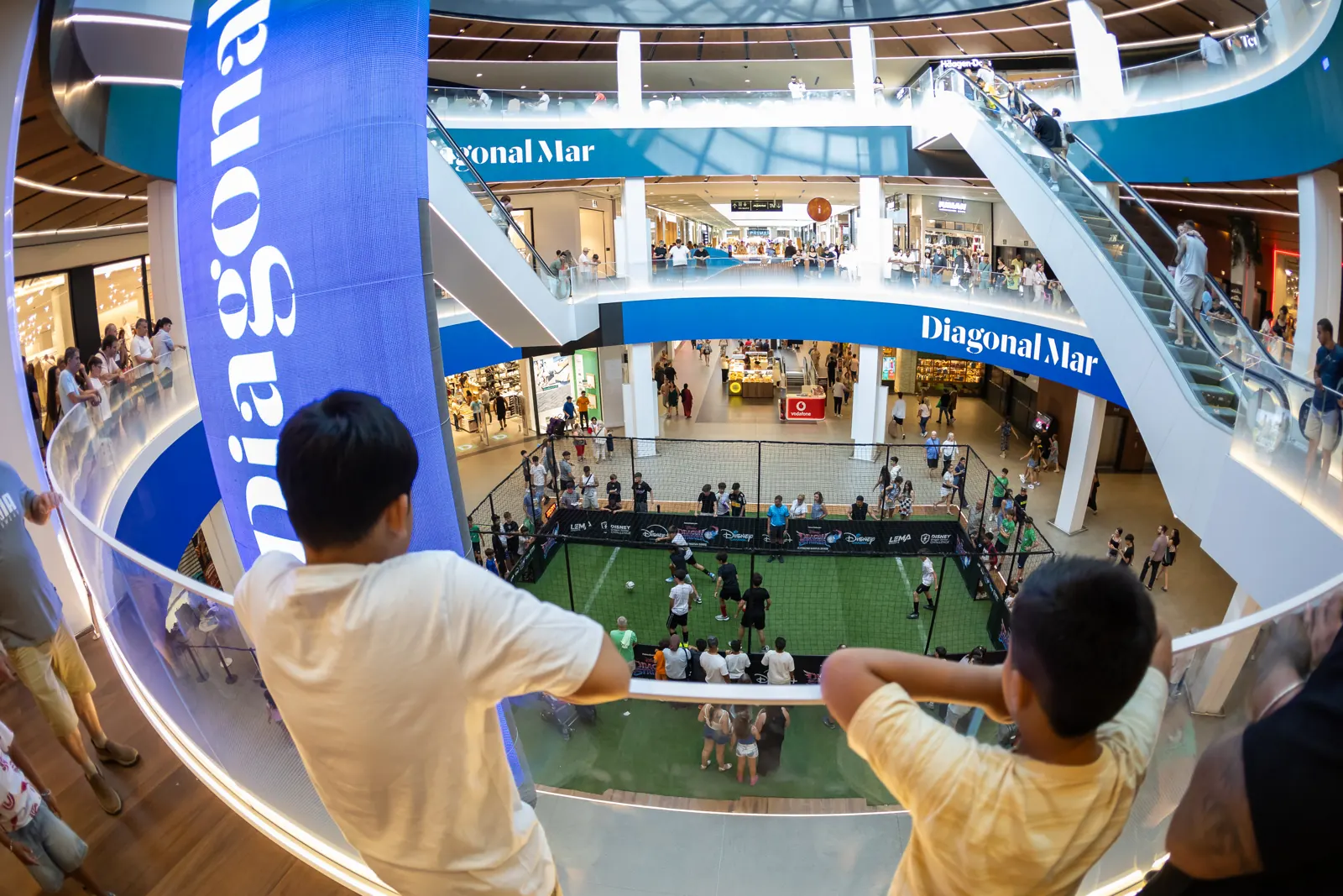 Niños siguen un partido desde los balcones del centro comercial Diagonal Mar, Barcelona